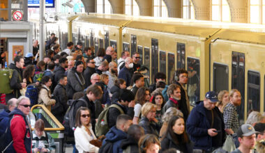 Menschen stehen am Bahnhof vor der S-Bahn
