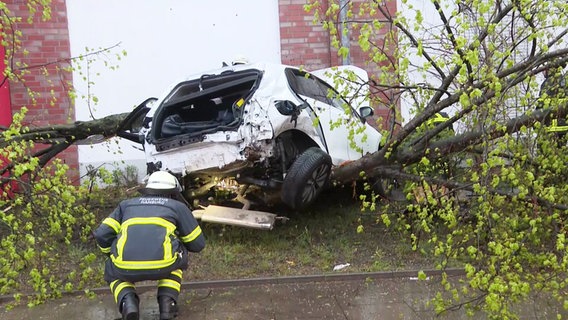 Ein Feuerwehrmann kniet vor einem Unfallauto, das in eine Supermarktwand gekracht war. © DSLR News Foto: Screenshot