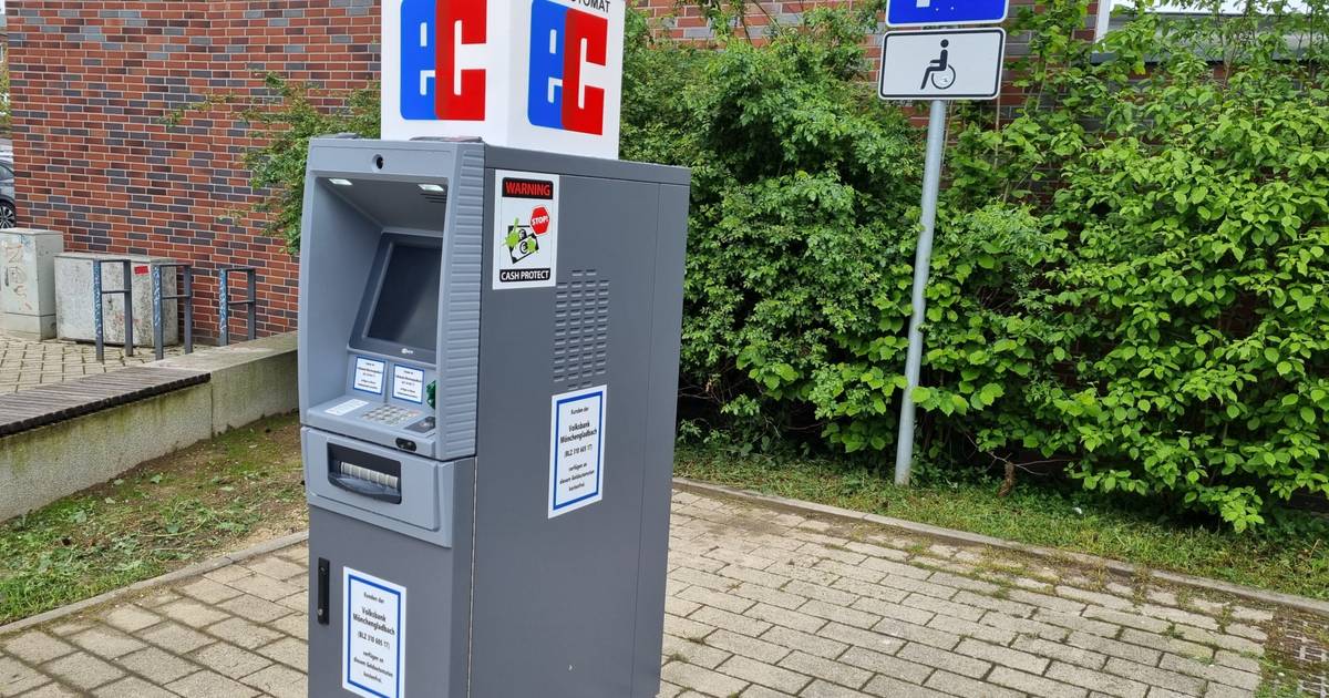 Hier steht ein einsamer Geldautomat auf dem Parkplatz