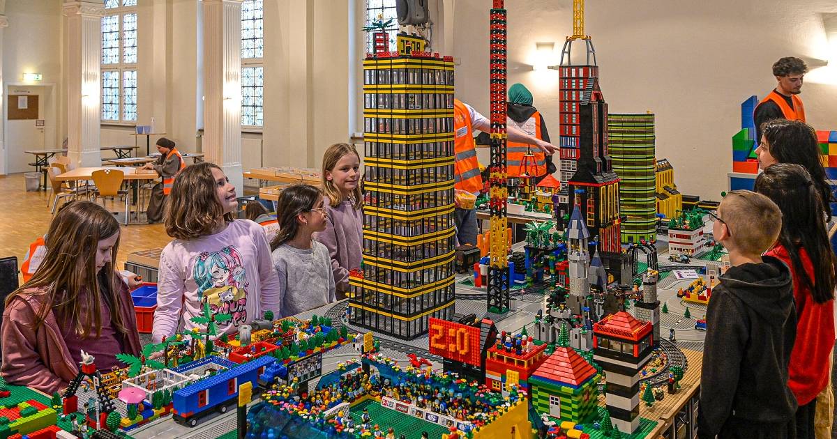 Kinder bauen eine Legostadt aus über hunderttausend bunten Steinen 