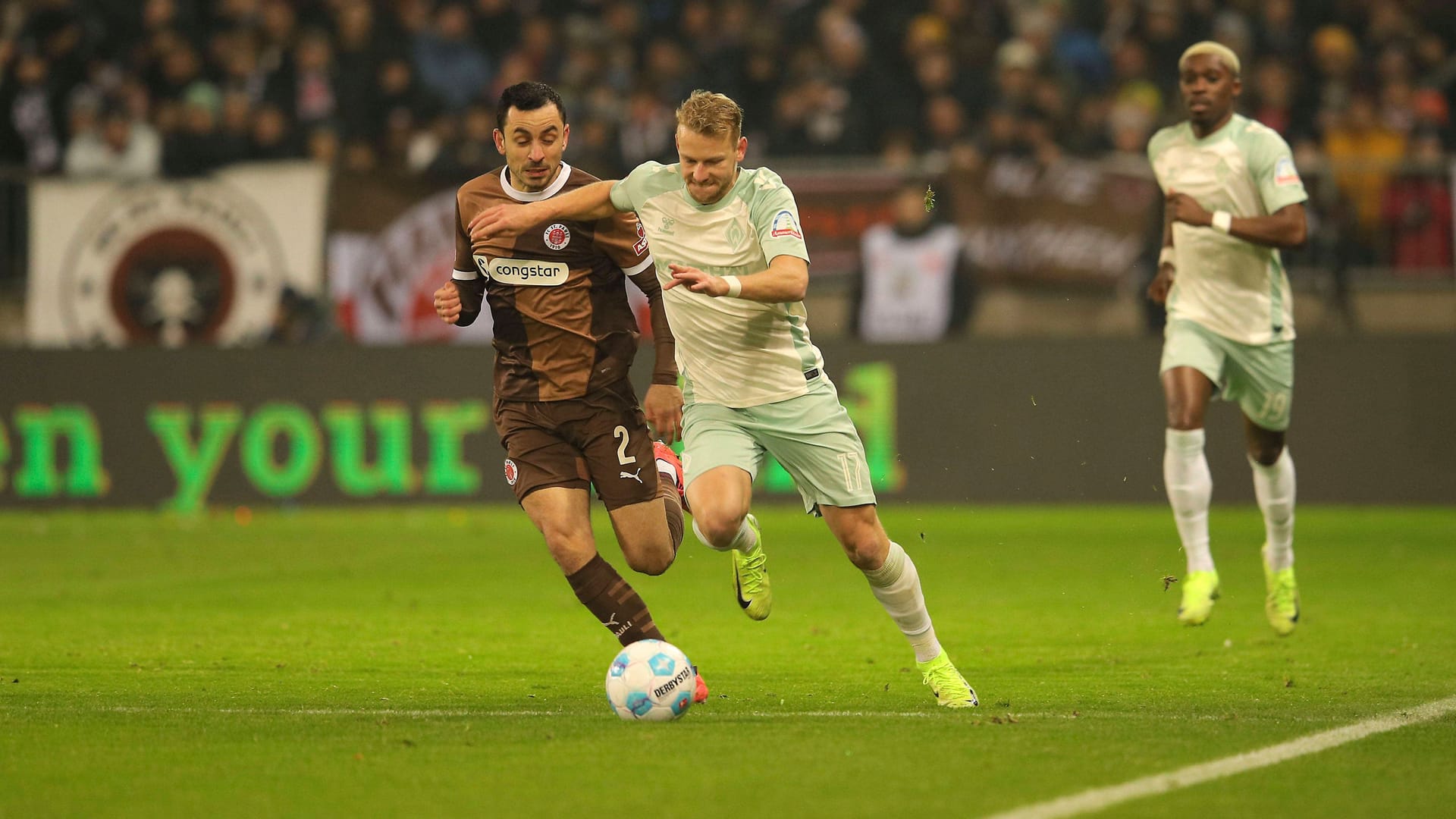 Werders Marco Grüll (r.) im Duell mit Manolis Saliakas (Archivbild): Am Sonntag wollen die Bremer gegen St. Pauli das fünfte Spiel in Folge gewinnen.