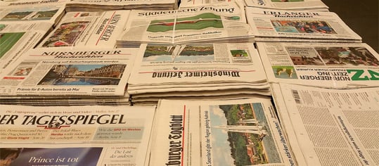 Verschiedene Tageszeitungen auf einem Tisch.