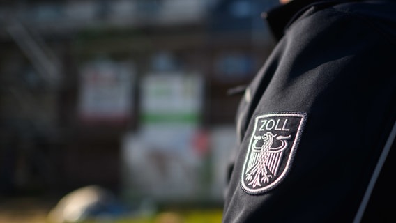 Ein Zollbeamter steht bei einer Kontrolle von Schwarzarbeit in einem Neubaugebiet. © picture alliance/dpa Foto: Julian Stratenschulte