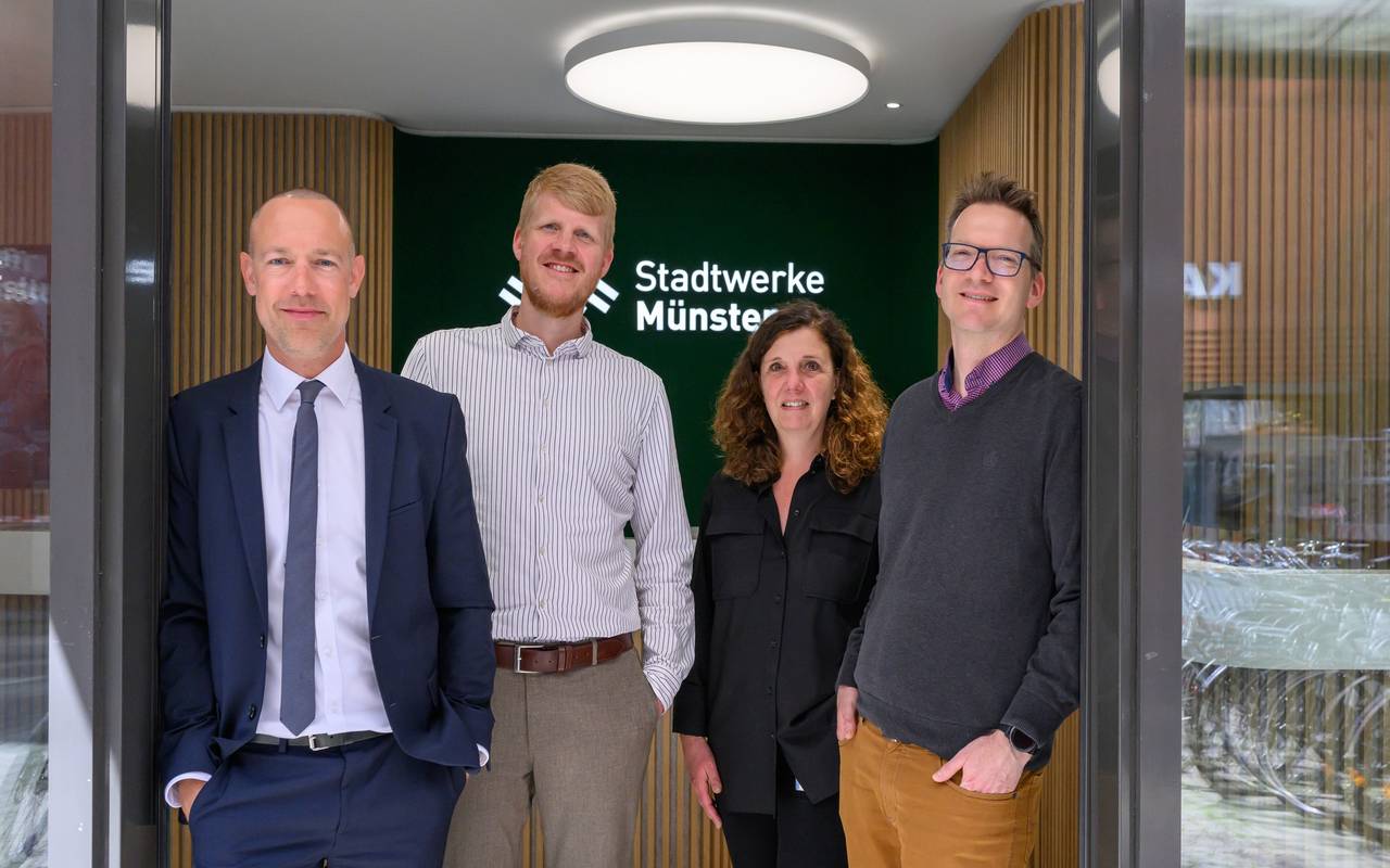 Vier erwachsene Personen in einem Gebäude der Stadtwerke Münster.