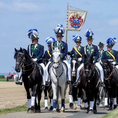 Zu sehen sind Reiter mit einer Flagge.