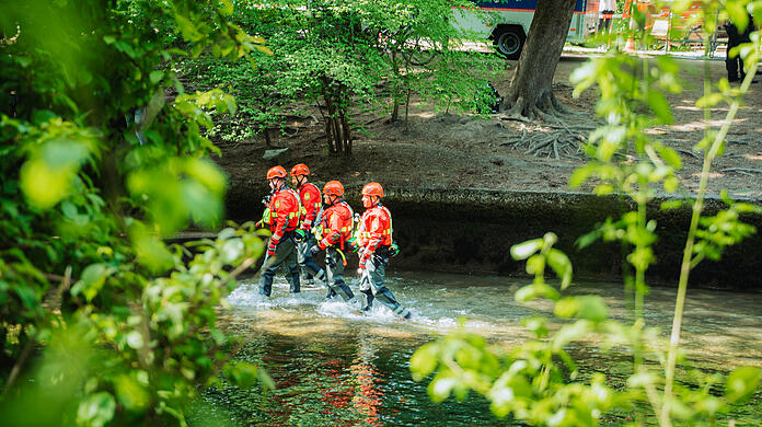 Vier Polizeitaucher steigen am Mittwoch gegen 12.45 Uhr an der Eisbachwelle ins Wasser, um den Grund akribisch abzusuchen. Eineinhalb Stunden werden sie im Wasser im Einsatz sein.