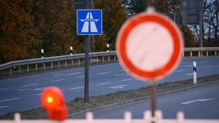 Ein "Fahrverbot in beide Richtungen"-Schild steht vor einer gesperrten Autobahn.