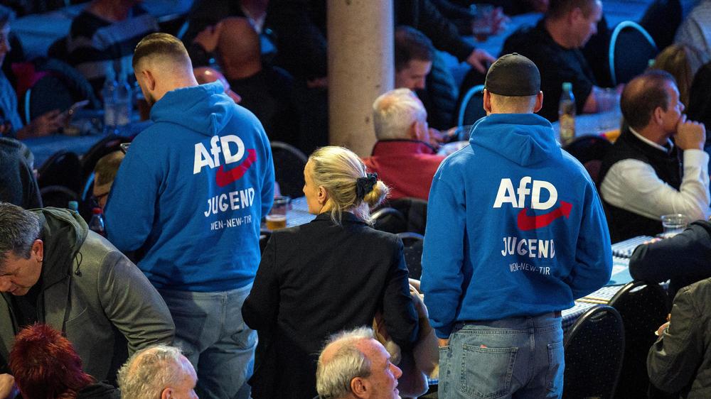 Umfrage: Zwei Männer tragen auf einer Wahlkampfveranstaltung Pullover mit der Aufschrift "AfD Jugend". In einer Umfrage spricht sich fast die Hälfte der Befragten für ein Verbot der Partei aus.