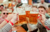 Besucher des 85. Stuttgarter Frühlingsfests stoßen in einem Festzelt mit ihren Maßkrügen an. Das 85. Stuttgarter Frühlingsfest findet von 19. April bis 11. Mai 2025 auf dem Cannstatter Wasen statt.
