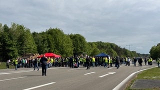 Viele Menschen stehen in einer Gruppe auf einer Straße - Protest der Zivilbeschäftigen an der Air Base Ramstein 