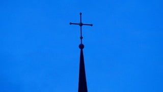 Evangelisches Kreuz vor blauem Himmel 