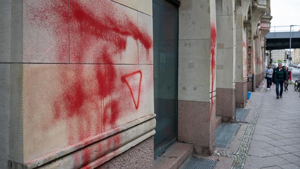 Humboldt-Universität zu Berlin: Ein Dreieck in roter Farbe ist neben verschmierter Farbe an der Fassade des Instituts für Sozialwissenschaften der Humboldt-Universität zu sehen. Auch das Hauptgebäude ist betroffen.