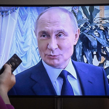 A woman watches a documentary on Russian President Vladimir Putin released on Russian state TV in Moscow on May 4, 2025. (Photo by Alexander NEMENOV / AFP)