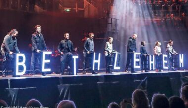 Menschen stehen auf einer Bühne und halten Buchstaben, die zusammen "Bethlehem" ergeben
