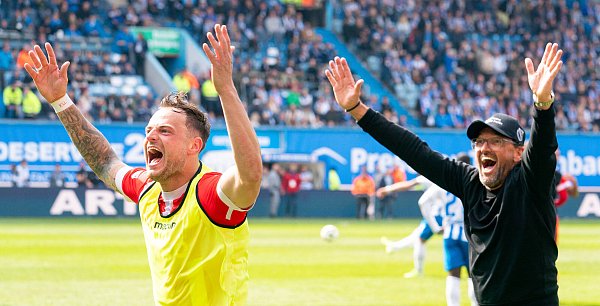 Die Cottbuser Timmy Thiele und Trainer Claus-Dieter Wollitz feiern den 3:1-Sieg bei Hansa Rostock. - © IMAGO/Ostseephoto