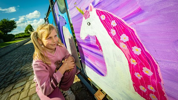 Die siebenjährige Lisa stellt ihr Einhorn mit blumendurchwirkter lila Mähne am Zaun der Burg aus. - © Mike-Dennis Müller