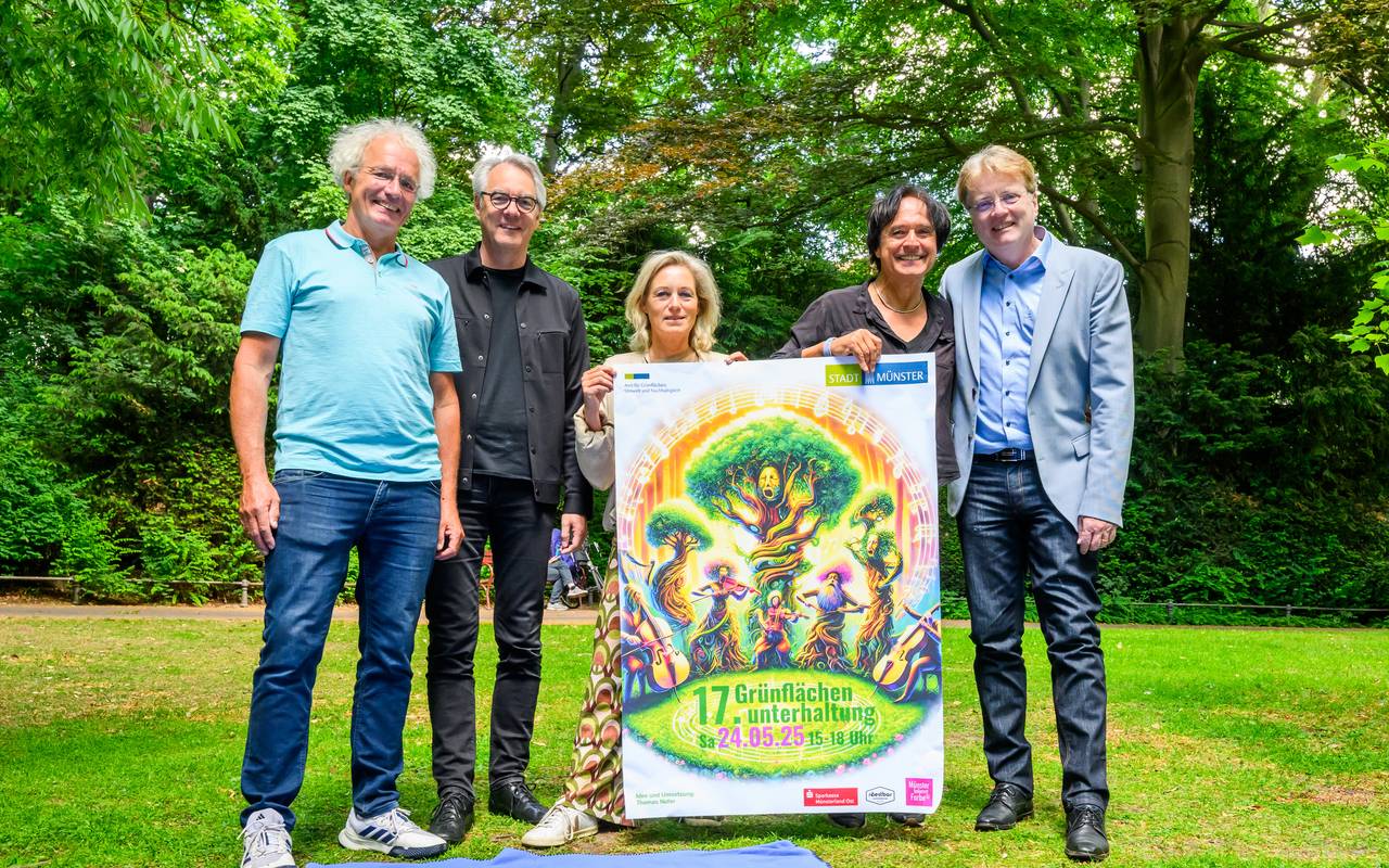 Fünf Menschen stehen an der Promenade und zeigen ein Plakat.