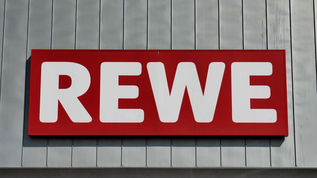 Logo von Rewe an einer Fassade.