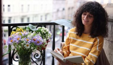 Eine junge Frau liest ein Buch auf einem Balkon (Symbolfoto)