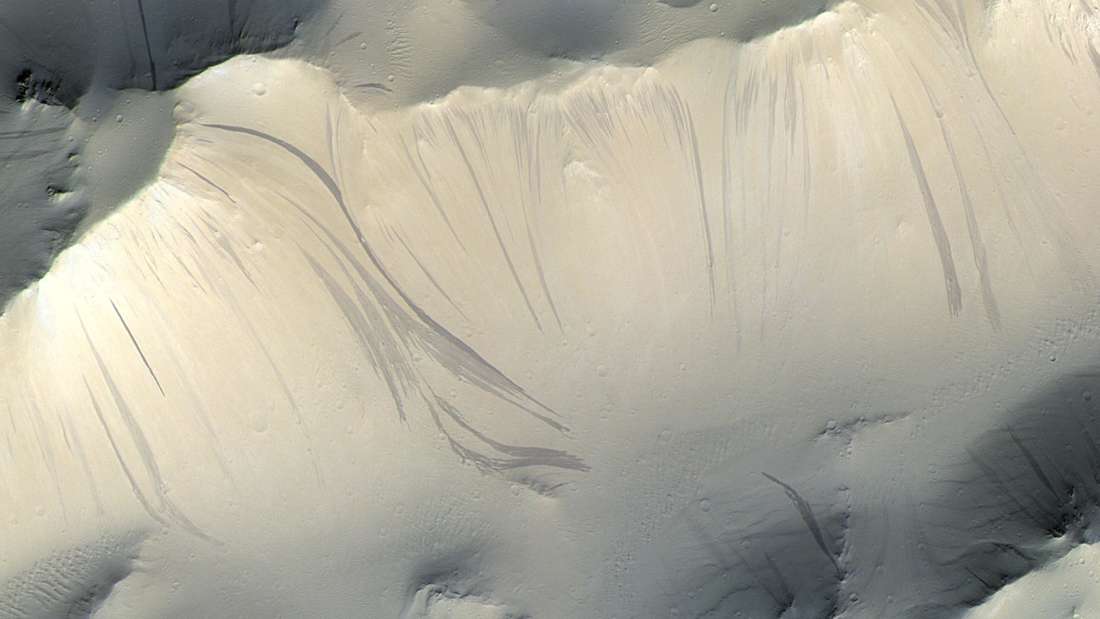 Helle und dunkle Schlieren auf den Abhängen des Olympus Mons, dem größten Berg des Mars. Aufgenommen von der CaSSIS-Kamera an Bord des europäischen ExoMars-Orbiters TGO.