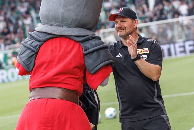 Union-Trainer Steffen Baumgart hat Zei...en Handshake mit dem Club-Maskottchen.  | Foto: Andreas Gora/dpa