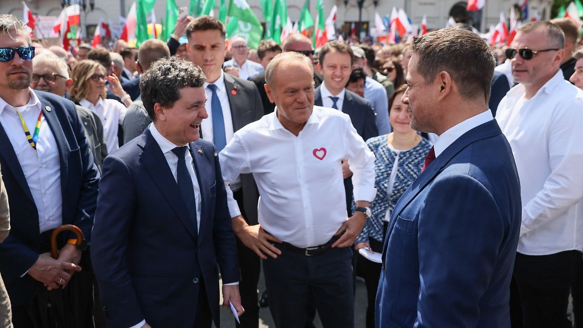 Der Bürgermeister von Warschau und Kandidat der Bürgerkoalition für die polnischen Präsidentschaftswahlen, Rafal Trzaskowski (r.), der gewählte rumänische Präsident Nicusor Dan (l.) und der polnische Ministerpräsident Donald Tusk (m.) nehmen am Großen Marsch der Patrioten in Warschau teil.