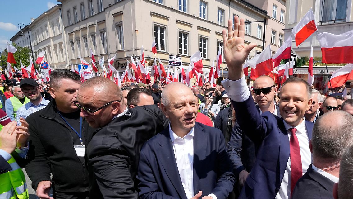 Der konservative Präsidentschaftskandidat Karol Nawrocki (r.) winkt beim "Großen Marsch für Polen" in Warschau.