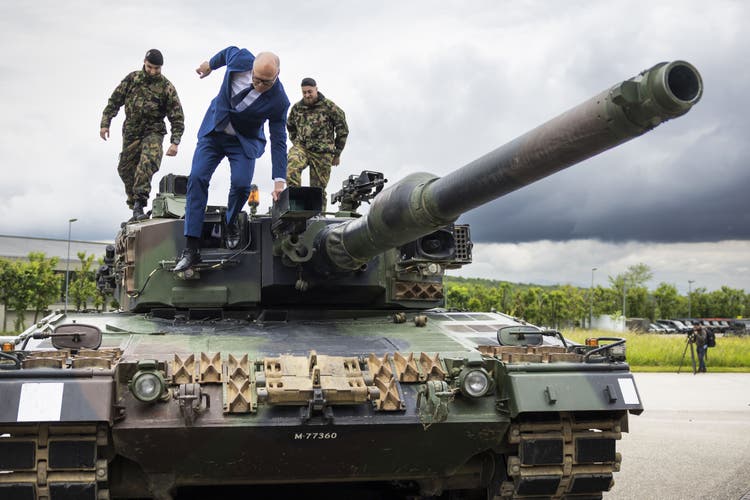 Keine Berührungsängste mit der Truppe: Bundesrat Martin Pfister (blauer Anzug) steigt vom Panzer, auf dem er mit zwei Soldaten diskutiert hat.