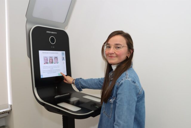 Eine Frau steht an einem Fotoautomaten.