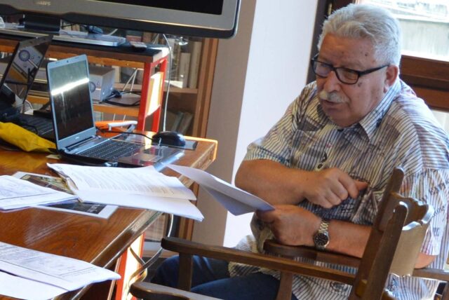 Bodo Stratmann sitzt mit historischen Aufzeichnungen am Tisch.