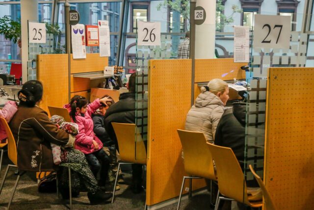Frauen und Männer an Bearbeitungsplätze der Bürgerdienste im Stadthaus