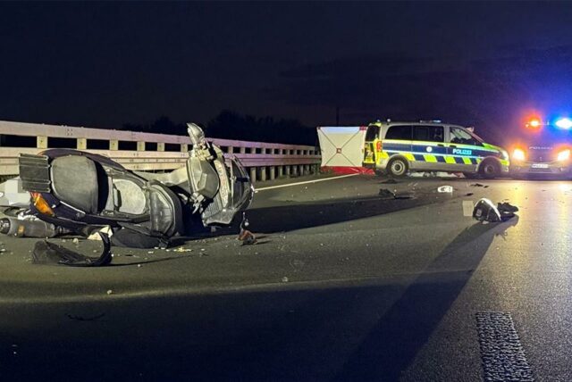 Ein Einsatzfahrzeug mit Blaulicht auf der Autobahn, dahinter wartende Autos