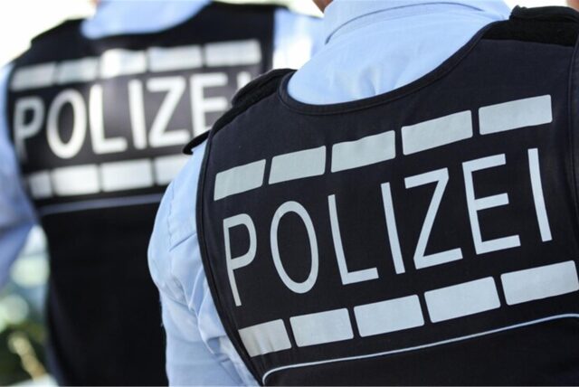 Zwei Polizisten mit Warnweste und der Aufschrift „Polizei“.