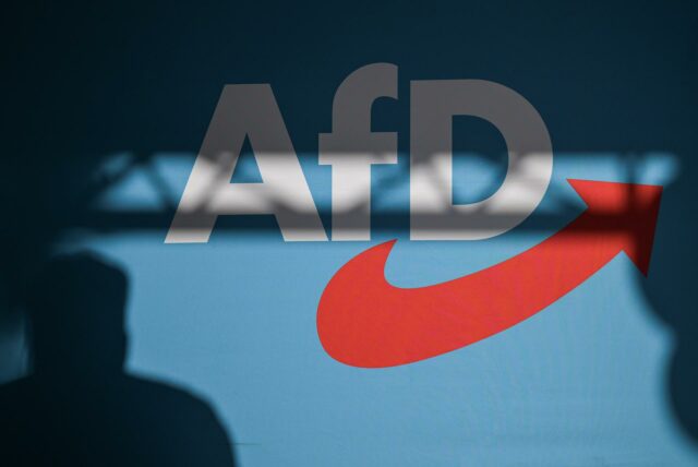 Eine Person wirft einen Schatten auf eine Wand mit dem AfD-Logo