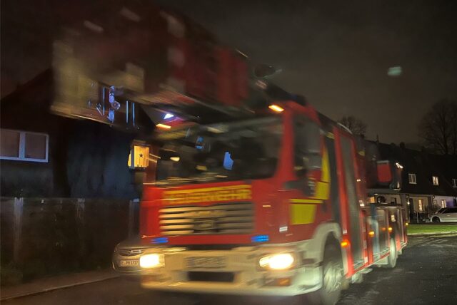 Ein Einsatzfahrzeug der Feuerwehr auf dem Weg zu einem nächtlichen Einsatz.