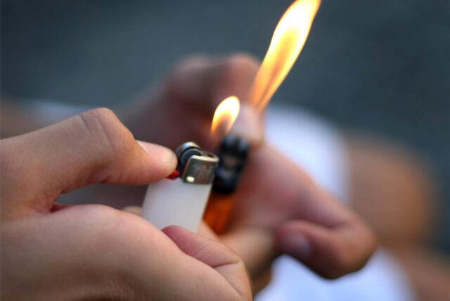 Eine Person hält Feuerzeuge in den Händen und hat sie entzündet. (Symbolbild)