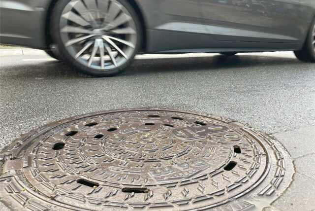 Schachtdeckel gibt es nahezu an jeder Straße. Sacken sie ab oder nimmt der Asphaltrand Schaden, bekommen Autofahrer Probleme (Symbolbild).