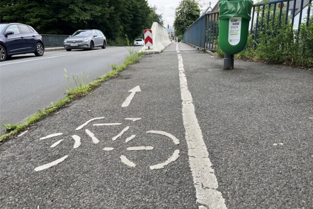 Ein Blick auf den Fahrrad- und Fußgängerweg an der Feldstraßenbrücke. Im Hintergrund stehen Autos in einer Schlange auf der Fahrbahn Richtung Süden.