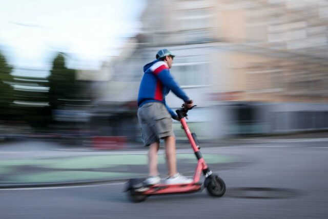 Ein Mann fährt auf einem E-Scooter