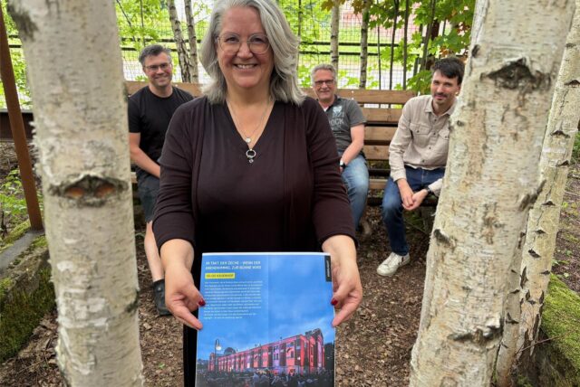 Mitorganisatorin Tanja Kramer hält eine Seite des Extraschicht-Programms auf der Neuen Zeche Westerholt in Händen, dahinter sitzen Christian Stoll (l.) und Christopher Fischer vom Circus Schnick-Schnack aus Herne sowie Bernd Lohse, Geschäftsführer der Zechen-Entwicklungsgesellschaft.