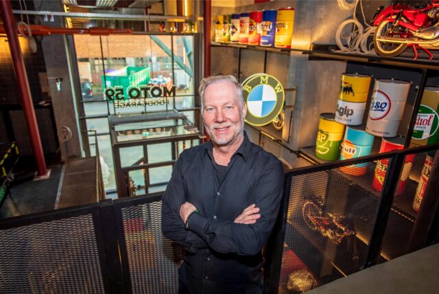 Carsten Kubacki, Mitbetreiber des Restaurants Foodgarage Moto59 in Herten, steht mit verschränkten Armen oberhalb des Foyers seines Restaurants.