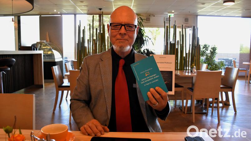 Martin Hauk zeigt das von ihm verfasste Buch "Lehrer mit Asperger: Cool, kompetent, anders – 22 Tipps für Lehrkräfte". Bild: ubb