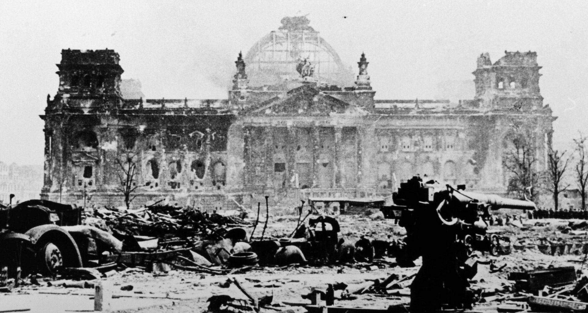 Ein verblichenes schwarz-weiß Foto des zerstörten Reichtagsgebäudes in Berlin im Mai 1945.