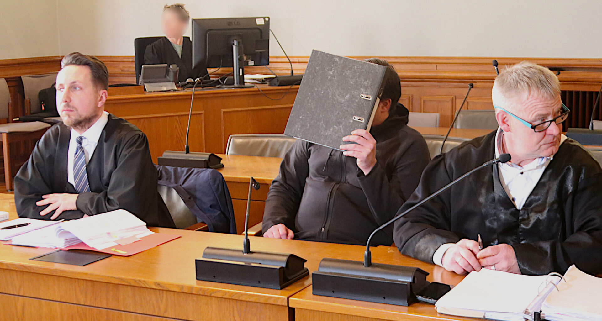 Angeklagter und Anwälte vor Gericht.