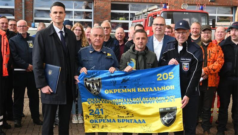 Vizekonsul Boris Drogomyretskyi, Grischa Kaflowsky, Sascha Kaflowsky, Landrat Thorsten Krüger (Cuxhaven) und Landrat Kai Seefried (von links) mit der ukrainischen Flagge.