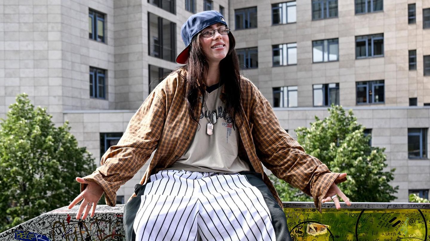 Die US-amerikanische Sängerin Billie Eilish sitzt auf der "Billie Eilish-Wand" in Berlin