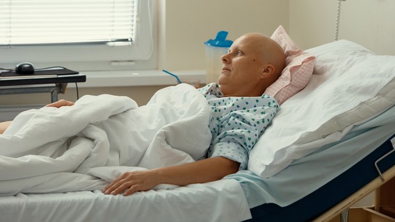Eine Frau mit kahlem Schädel liegt in einem Krankenhausbett. © PantherMedia Foto: artush