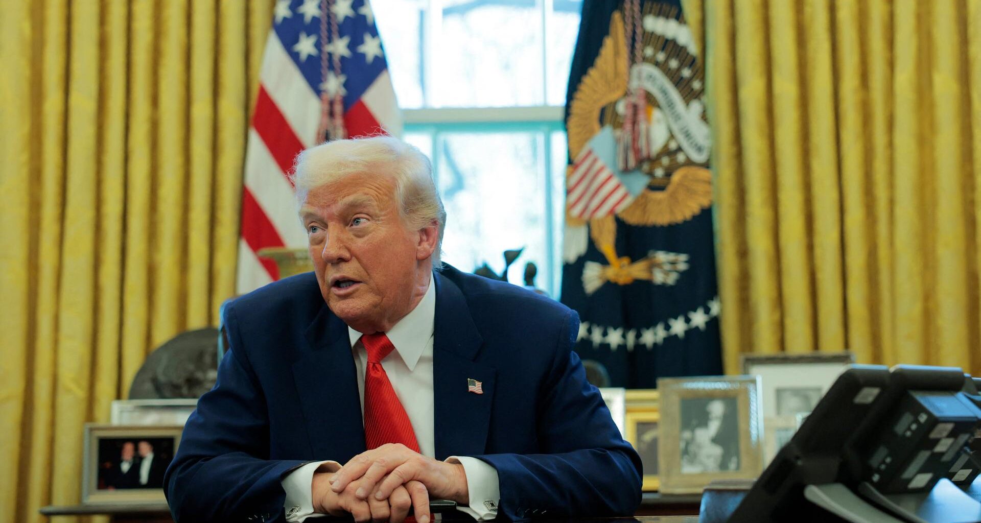 US-Präsident Donald Trump sitzt an seinem Schreibtisch im Oval Office und spricht.