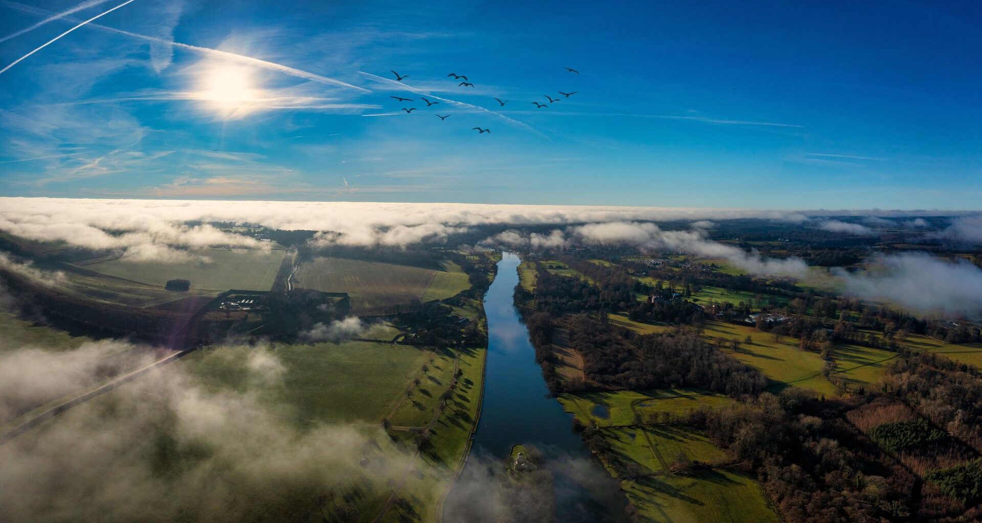 Ein Luftbild der Stadt Henley-on-Thames umgeben von grünen Feldern und Wasser.