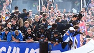 HSV-Fans jubeln bei der Aufstiegsfeier an der Binnenalster den HSV-Teams der Frauen und Männer auf einem Truck zu. © Witters/ValeriaWitters 
